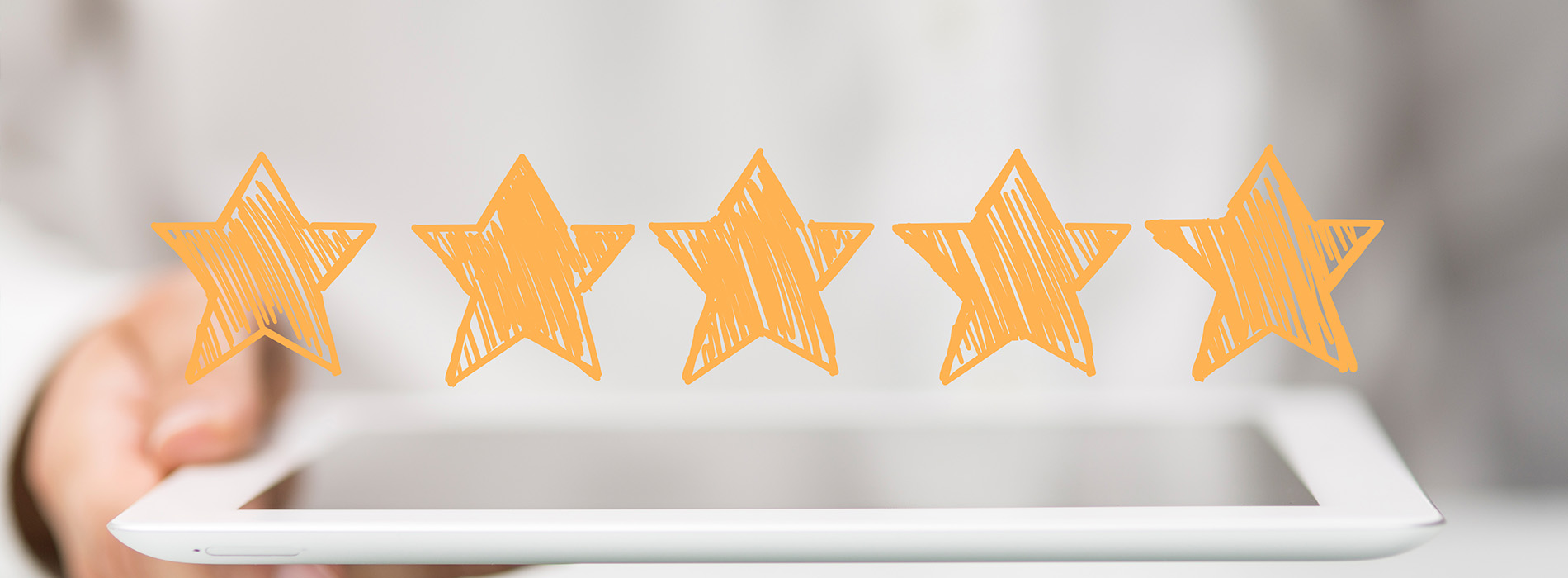 This is an image of a person s hand holding a tablet with a graphic of three gold stars on it, against a blurred background that suggests a positive customer review or rating system.