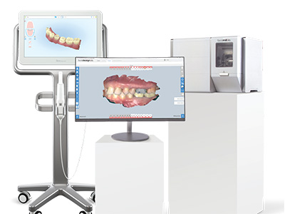 The image displays a dental office setup with various pieces of equipment, including a computer monitor displaying dental imaging, a large 3D model of a human mouth, and other dental tools and devices.