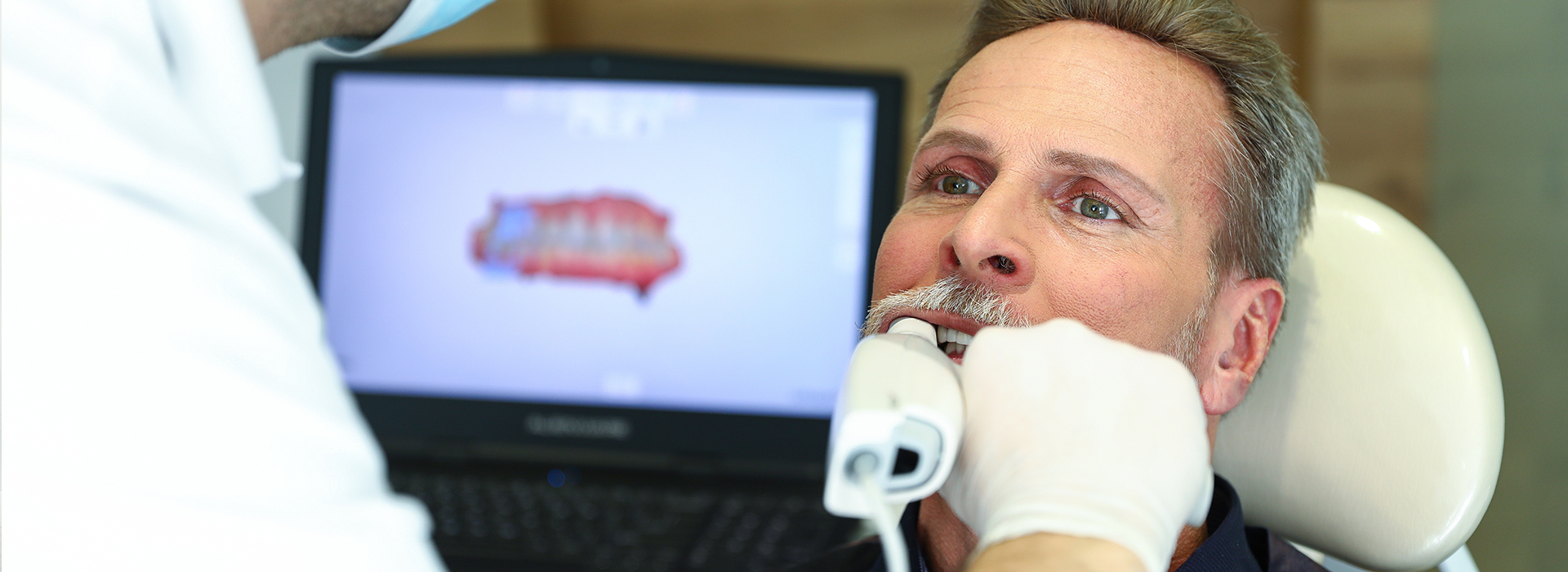 Man receiving dental care in a professional setting, with a dentist performing a procedure.